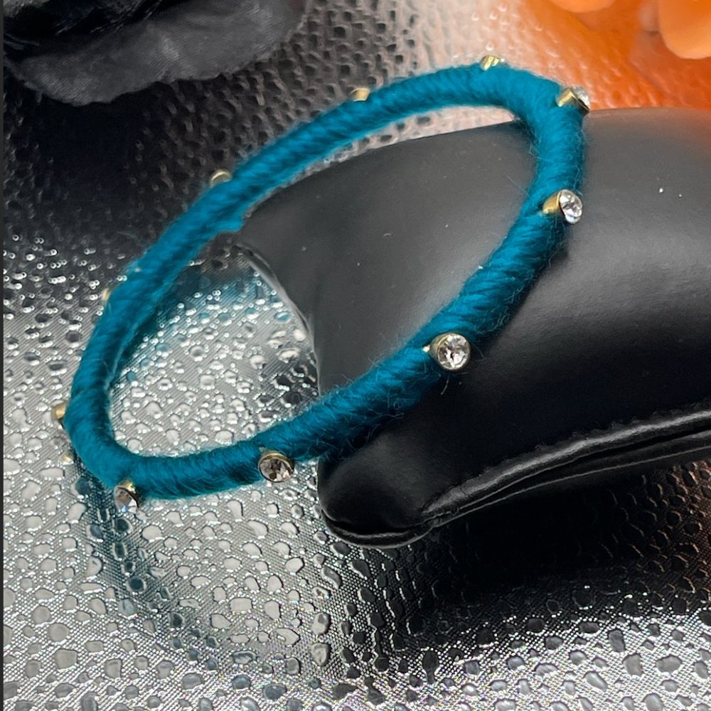 10.21.23.9 Turquoise colored yarn covered bracelet with rhinestones